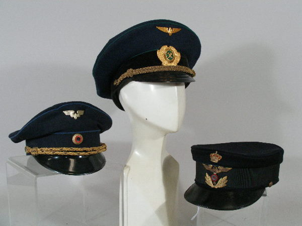 Three Vintage Foreign Railroad Conductor Hats,: Group of Three Foreign Railroad Conductor Hats, a pre-WWI German visor hat, black wool w/silk band and attached embroidered emblems (deterioration to sweatband); a 1960s German railroad visor, blue wo