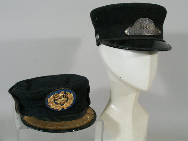 Two Vintage British Railroad hats,: Two British Railroad hats, a 1950 conductor visor hat, black silk w/metal badge "C.F.L #226" (Cornwall, Tarborough, London); and a 1960s conductor hat, blue gray wool w/gold cording, British Rail gold