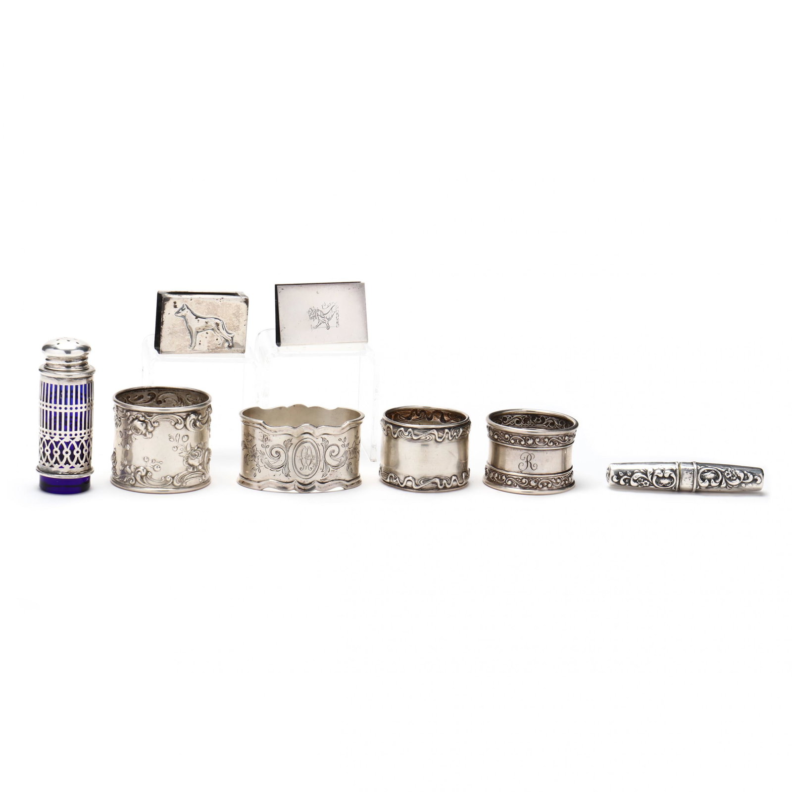 A Grouping of Eight Sterling Silver Table Accessories: A Grouping of Eight Sterling Silver Table Accessoriesincluding (2) round napkin rings by Gorham, pattern numbers B2031 and 524, each with raised scrolling floral borders (1 1/2 x 1 3/4 in. tallest); n