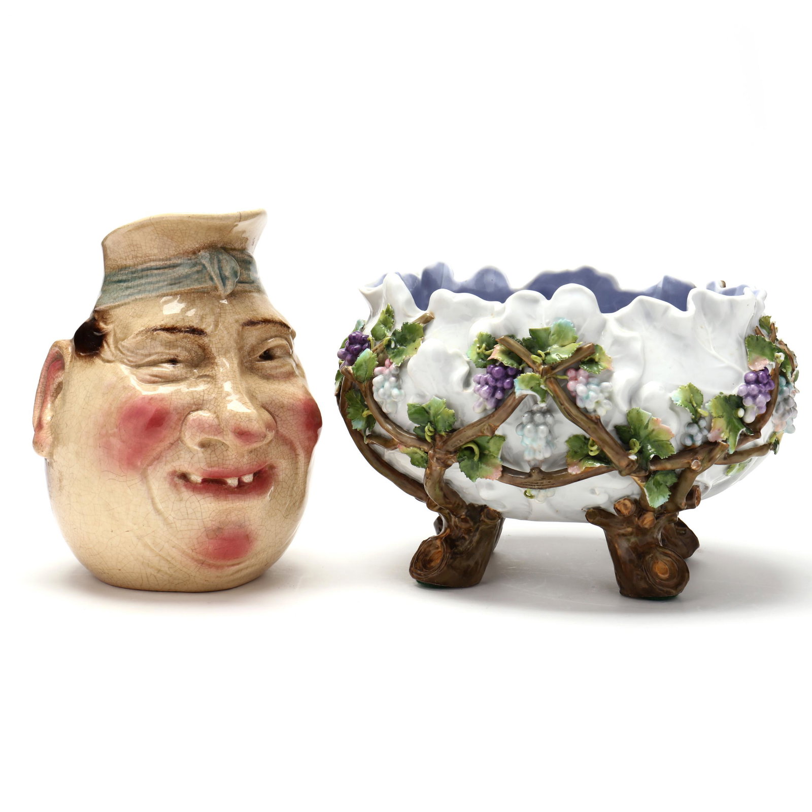 Two French Decorative Pieces: Two French Decorative Pieces 19th century, a Sarreguemines #3181 character jug of a corpulent man (allover crazing; two lip hairlines) (8 1/2 x 8 in.) and a porcelain coupe bowl with applied grape vin