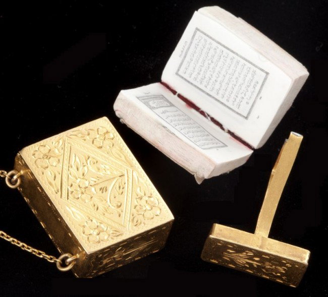 Gold Koran Locket Necklace: Gold Koran Locket Necklace designed as an engraved box in a floral motif which slides open to hold a miniature full text version of the Koran, attached to a small oval link chain, mounted in 18KT yell