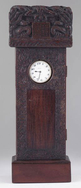 Chinese Box with Eterna Watch: Chinese Box with Eterna Watch probably late 19th century, relief carved rosewood and mahogany case in the form of a tall case clock. The hinged door displays a clock face and opens to a storage compar