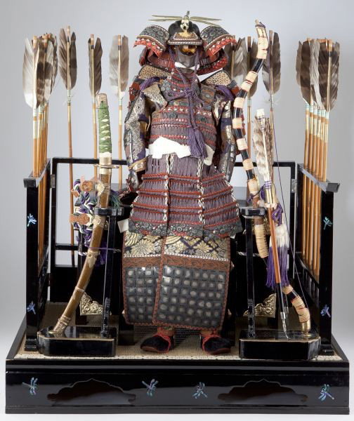 Japanese Samurai Armor and Weapons Model: Japanese Samurai Armor and Weapons Model 20th century, includes a bow, (20) arrows, a katana sword, plate armor with embroidered elements and a black lacquer storage box mounted with brass. A dais con