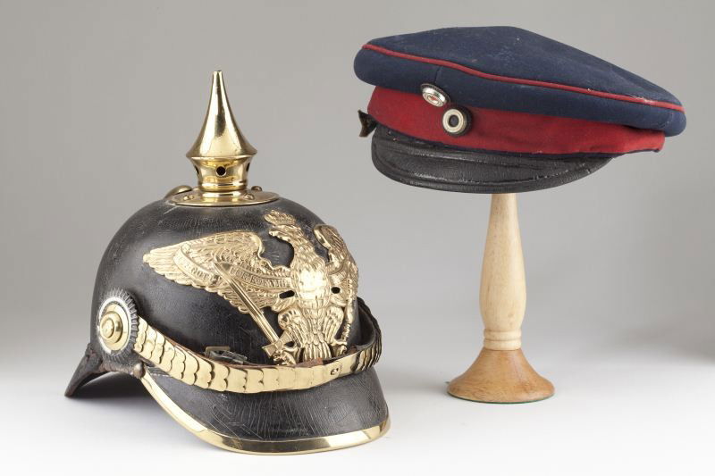 Imperial German Pickelhaube and Visor Cap: Imperial German Pickelhaube and Visor Cap the helmet of leather construction with applied brass elements, the interior dated 1883. The wappen oddly lacks the characteristic "FR" on its breast. Crazed