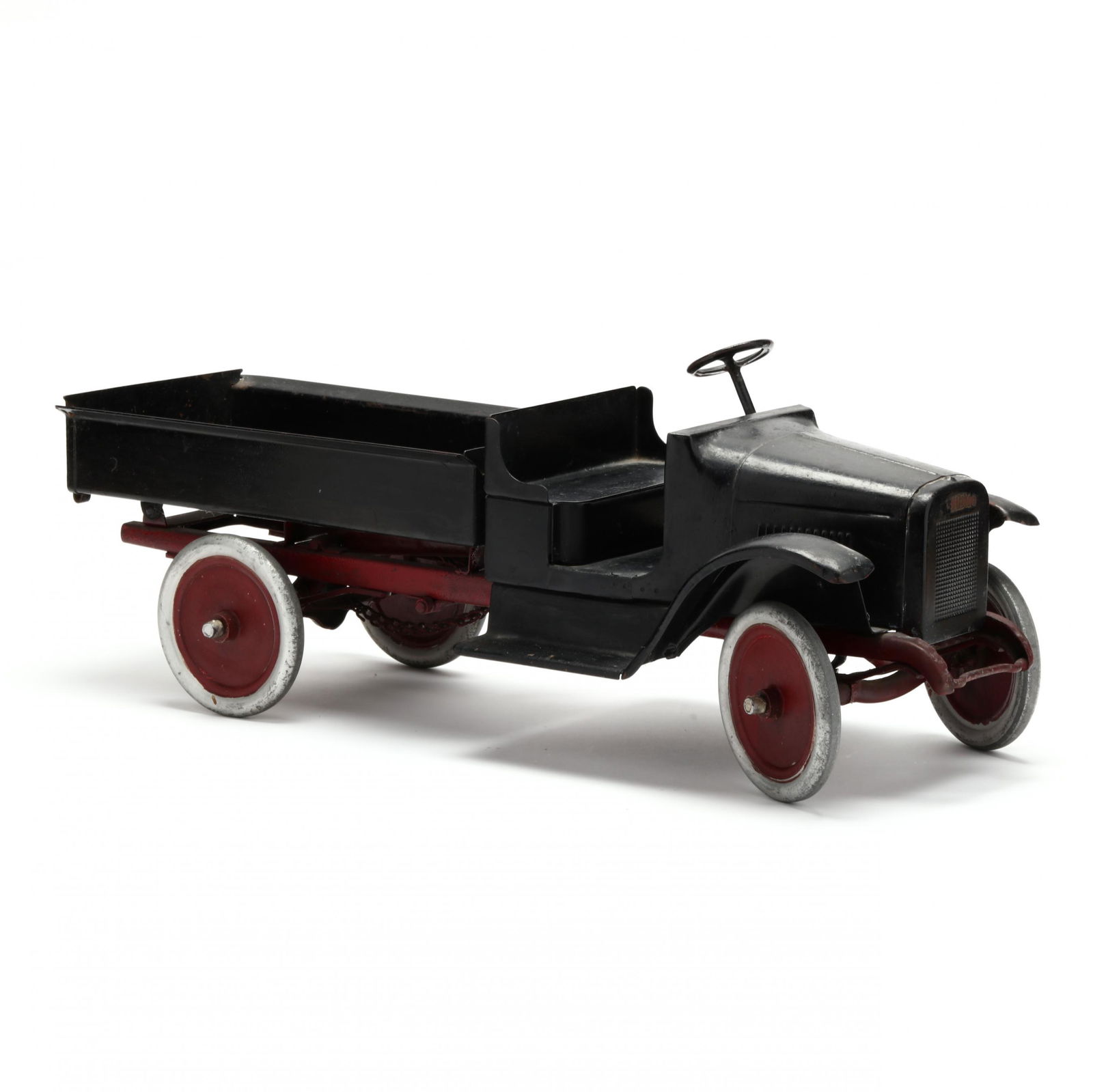 Buddy L Pressed Steel Dump Truck: Buddy L Pressed Steel Dump Truck1920s, truck with topless cab, hand crank on chassis winds and unwinds cords mounted to pulley on the frame raising the truck bed, original decal below dash. Private Co