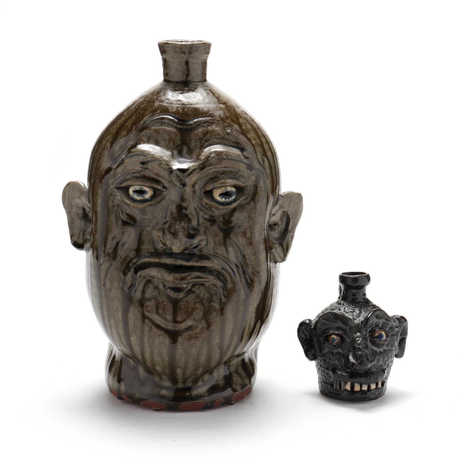 Marvin Bailey (SC, b. 1960), Two Face Jugs: Marvin Bailey (SC, b. 1960), Two Face Jugs the first is alkaline glazed with all around vertical runs, depressed scowling visage with pulled and applied features, signed near the rear base (12 1/2 in.