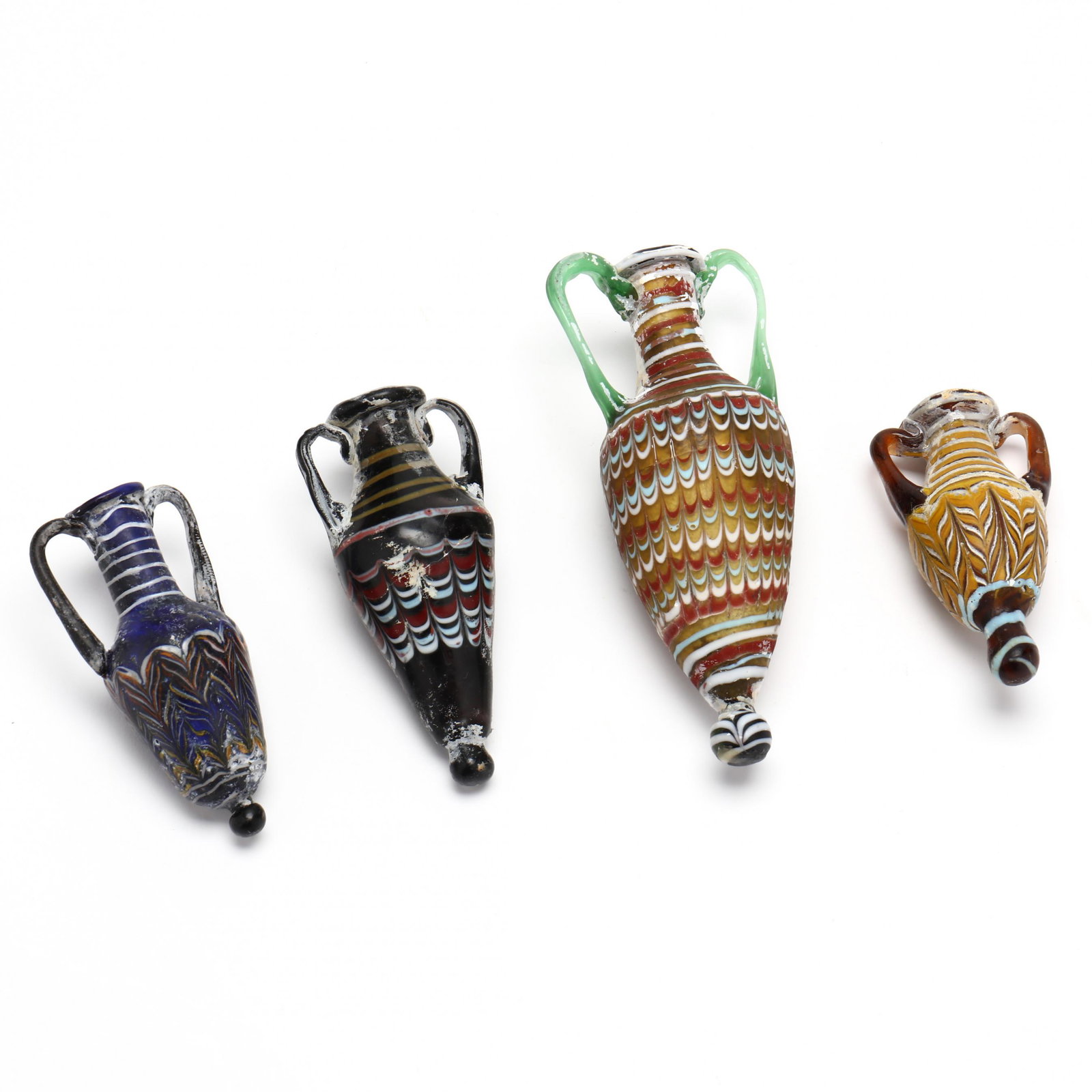 Four Phoenician Style Core Glass Amphoriskoi: Four Phoenician Style Core Glass Amphoriskoieach amphoriskos of multi-colored patterned glass after classical originals. The largest is 6-1/4 in. Private Collection of an Antiquarian, Charlotte, North