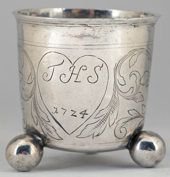Scandinavian Silver Beaker, circa 1724: Scandinavian Silver Beaker, circa 1724 barrel form with everted rim and raised on three applied ball feet, the body with period foliate scrollwork engraving, two heart form cartouches - one engraved "