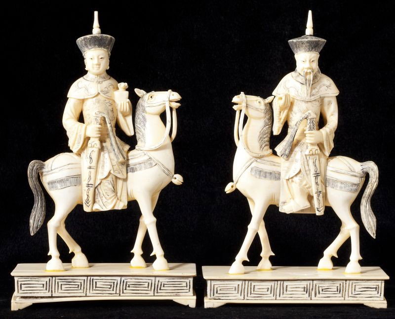 Pair of Antique Asian Ivory Figures on Horseback: Pair of Antique Asian Ivory Figures on Horseback a man and woman each carrying a sword sit with regal bearing upon their walking horses, raised on a footed platform base. HOA 8 in. Estate of the late 