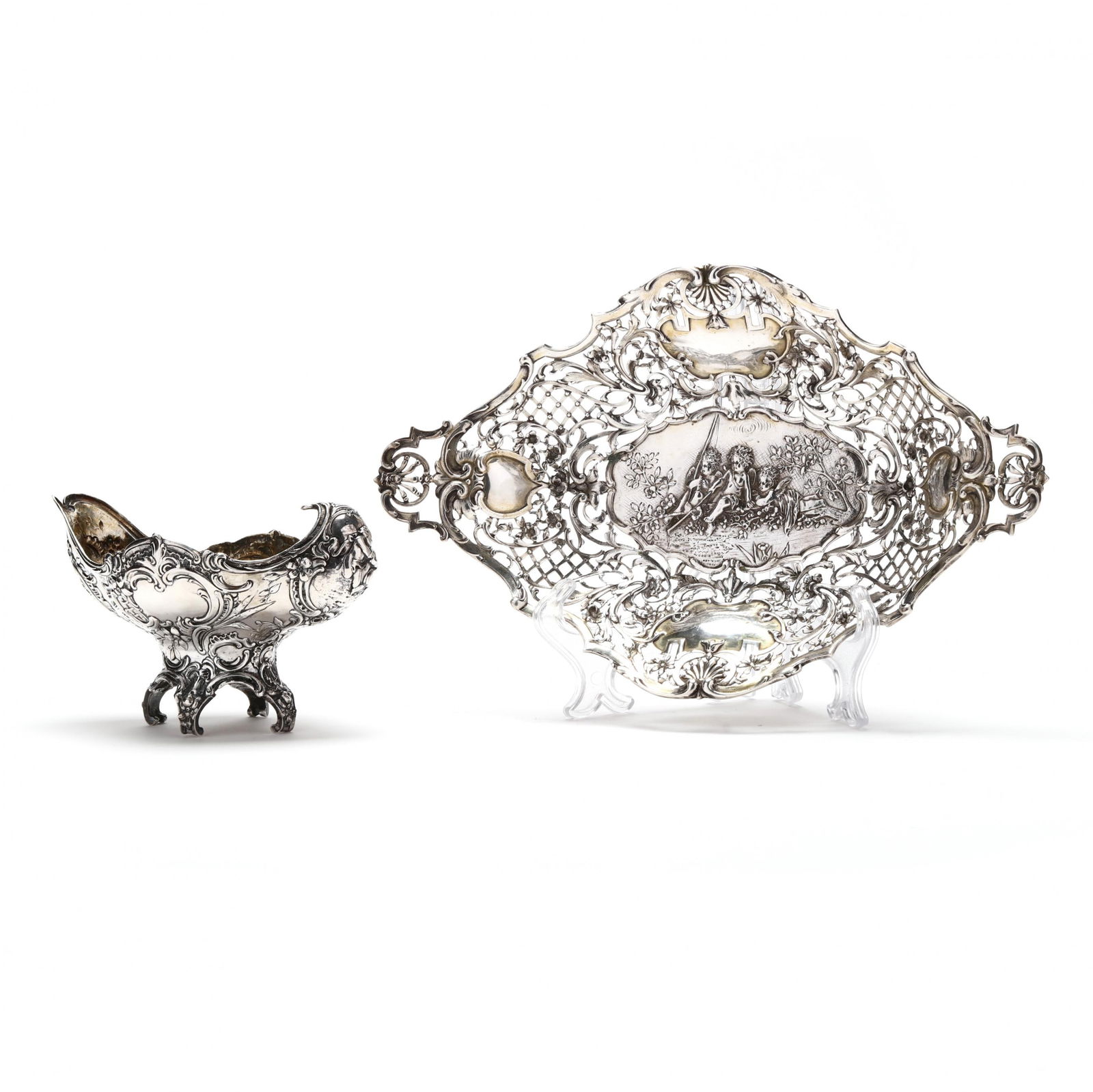 Two Hanau Silver Table Accessories: Two Hanau Silver Table Accessoriesthe first a boat form parcel gilt bowl, pseudo hallmarks to underside, in the Rococo taste with floral and scroll motif, the inward curved handle featuring a design o