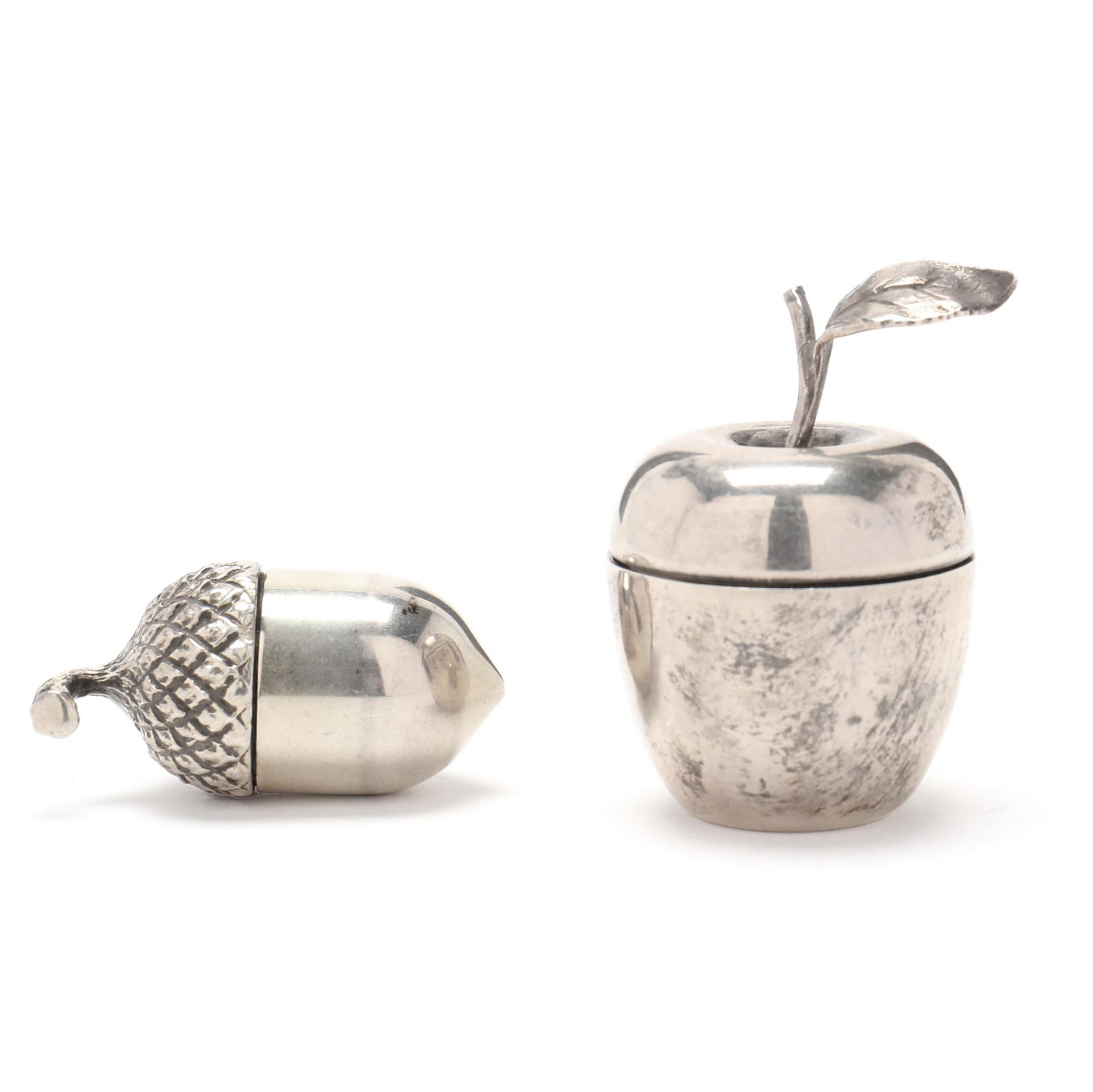 Two Tiffany & Co. Sterling Silver Apple and Acorn Pill Boxes: Two Tiffany & Co. Sterling Silver Apple and Acorn Pill Boxescontemporary, the first, apple form, pattern number 25008 (2 in.); the second, acorn form, marked "Sterling / Tiffany Co.", gold wash interi