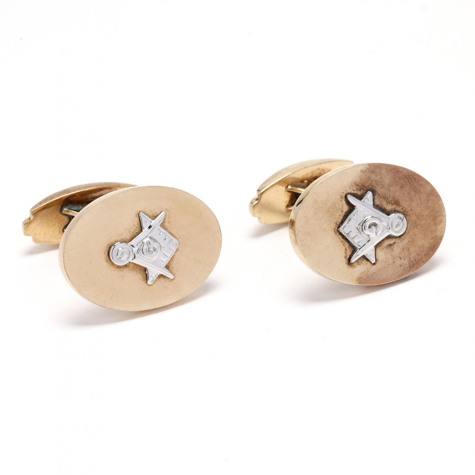 Bi-Color Gold Masonic Cufflinks: Bi-Color Gold Masonic Cufflinks of oval form, centered on the Masonic square and compass and completed with whale tail backs, stamped 10K ESEMCO and engraved S.W.J with date12-25-57. 13/16 in. 8.8 dwt