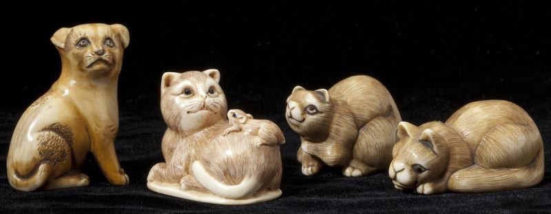 Group of Four Ivory Netsuke: Group of Four Ivory Netsuke to include (2) raccoon dogs, a seated pup, and a cat with a mouse upon its back, all with tinted highlights. 1 in. to 1.75 in. Estate of Dennis Patrick, MI