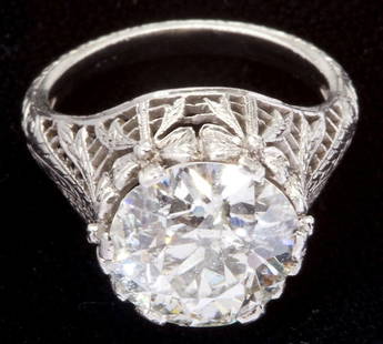 Large Edwardian Diamond Solitaire: Large Edwardian Diamond Solitairecentering on one Old European cut diamond weighing 4.16 carats (I2 clarity, K color) set within an exceptional platinum filigree mounting depicting bows which hold the