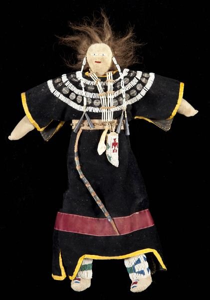 Vintage Sioux Doll: Vintage Sioux Dollearly 20th century, the dress of black velvet trimmed with burgundy and yellow silk, white beadwork across the torso and shoulders, the figure's belt is affixed with a small beaded h