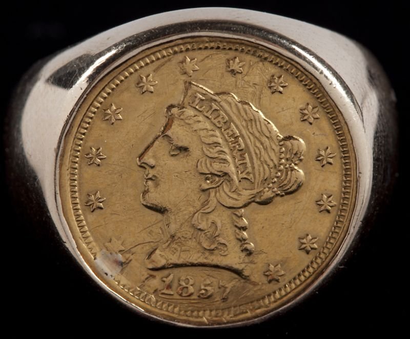 1857-O Liberty Head $2.50 Gold Coin in Gold Ring: 1857-O Liberty Head $2.50 Gold Coin in Gold Ring the quarter eagle, VF, with scratches near the date, a solder spot at the rim and overall light polish from wearing; the ring with wide tapering shank 