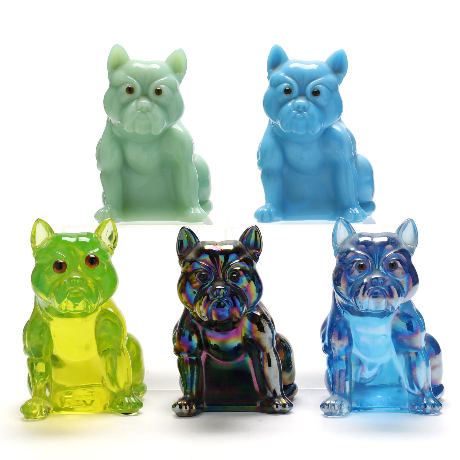 attributed Westmoreland, Five Glass Bulldog Doorstops: attributed Westmoreland, Five Glass Bulldog Doorstopsoriginally produced circa 1915, this selection being later produced, solid cast glass with adhered glass eyes, including one in uranium glass, one