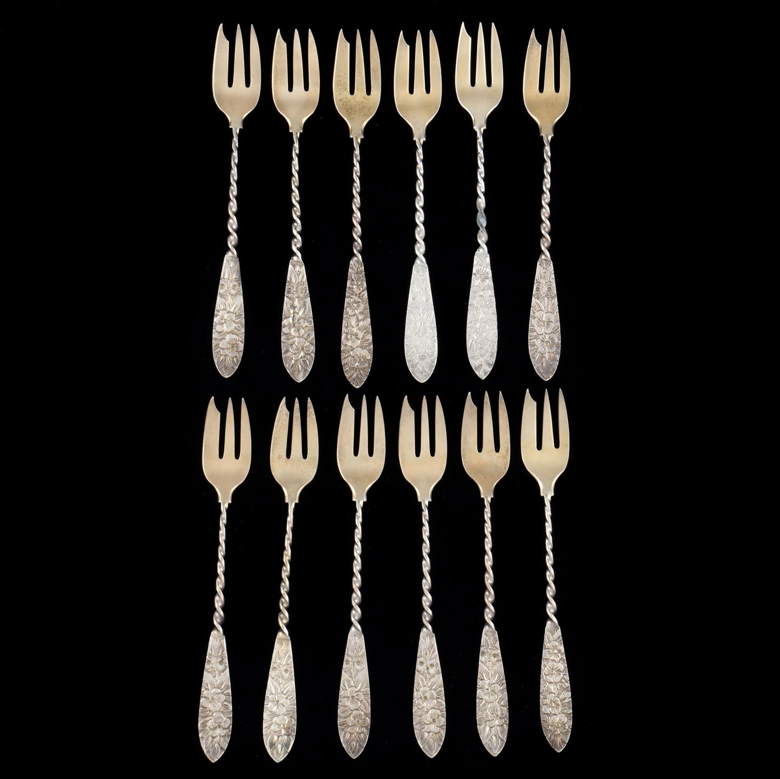 Set of Twelve Sterling Silver Twisted Handle Seafood Forks: Set of Twelve Sterling Silver Twisted Handle Seafood Forksretail mark of J.H. Johnston & Co., circa 1882-1889, each with hand-chased foliate handle and gold wash tines, monogrammed. 5 3/4 in. 4.8 tota