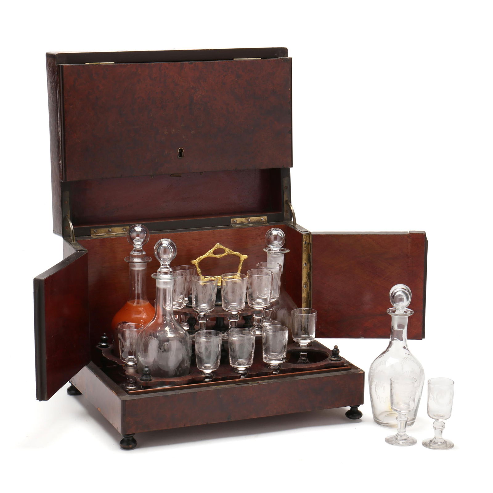 Antique French Burlwood Tantalus: Antique French Burlwood TantalusLate 19th century, rectangular form, the hinged front cover and sides open to reveal a brass and carved wood tiered stand holding four etched glass decanters and (14) c