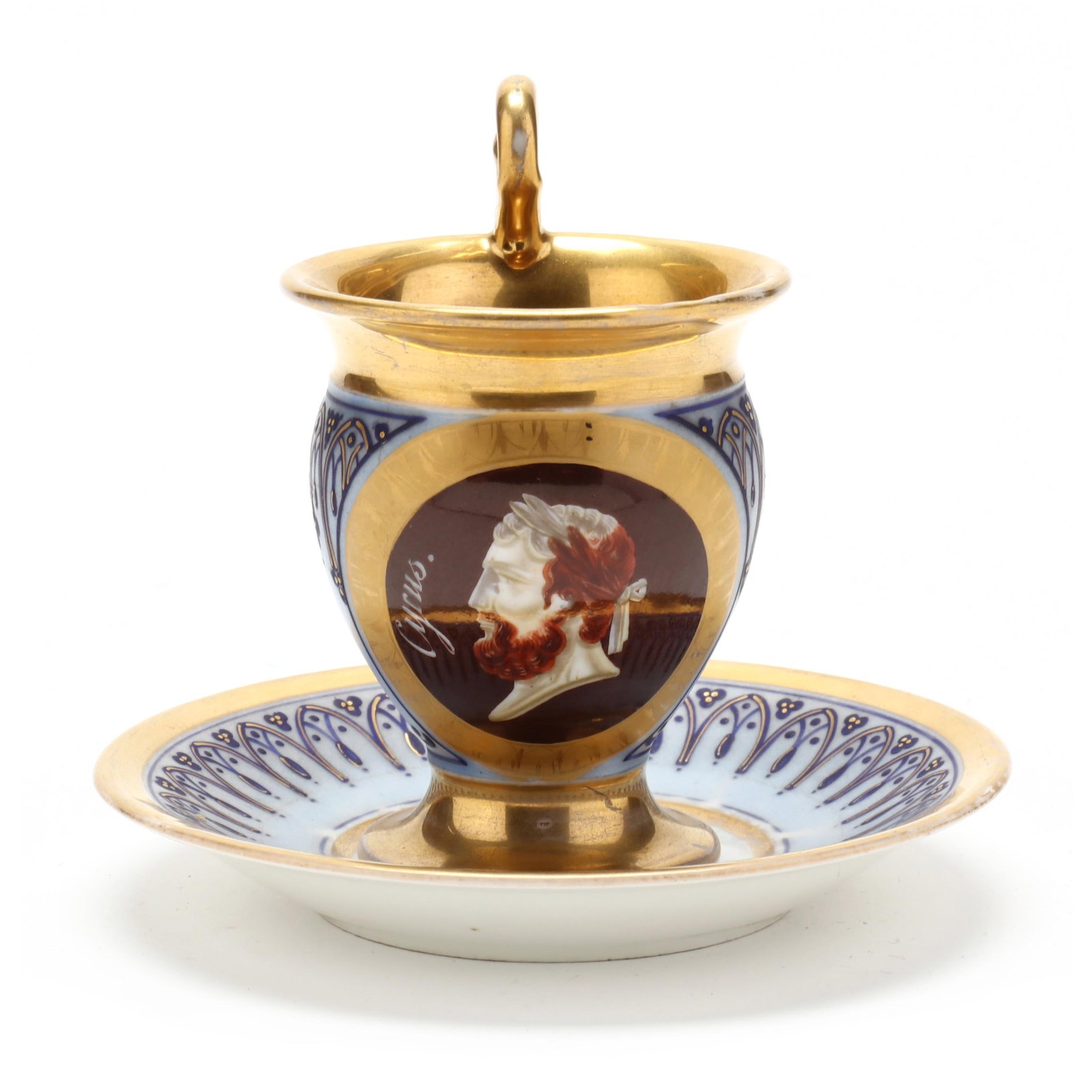 Neoclassical Style Parcel Gilt Cup and Saucer, Cyrus: Neoclassical Style Parcel Gilt Cup and Saucer, Cyrus 19th century, unmarked, blue with Persian style trefoil and niche motif borders with gilt decoration, featuring a Hellenized profile portrait of Cy