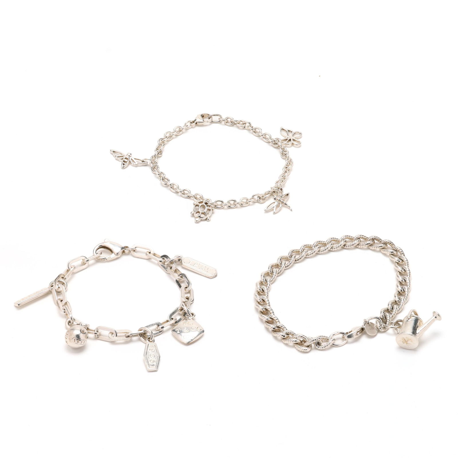 Group of Three Silver Charm Bracelets, Tiffany & Co.: Group of Three Silver Charm Bracelets, Tiffany & Co.to include: a cable bracelet suspending four charms: a bee; a turtle (.5 in.); a dragonfly (.75 in.); and a butterfly, completed with lobster clasp,