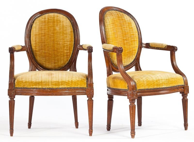 Two Similar Louis XVI Fauteuils: Two Similar Louis XVI Fauteuils third quarter 18th century, both with walnut frame carved with reeding and stop-fluting, seat rail with carved corner blocks, velvet and brass tack upholstery, one chai