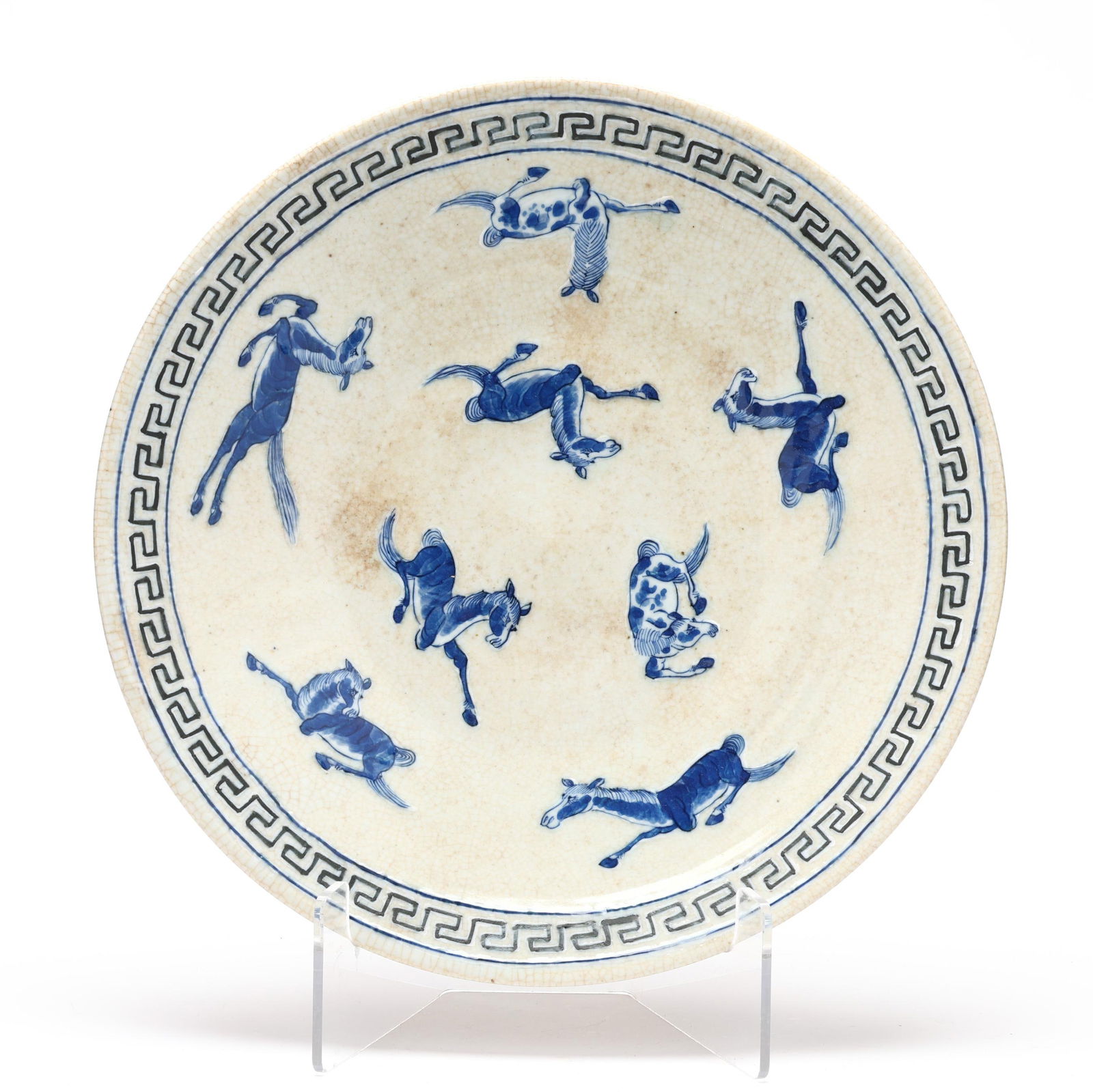 A Chinese Blue and White Charger with Horses: A Chinese Blue and White Charger with HorsesQing dynasty (1644-1912), 19th century, a large charger with tight crackle to cream glaze decorated with horses in blue and white enamels, rim is encircled