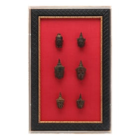 A Group of Six Southeast Asian Bronze Buddha Heads Framed