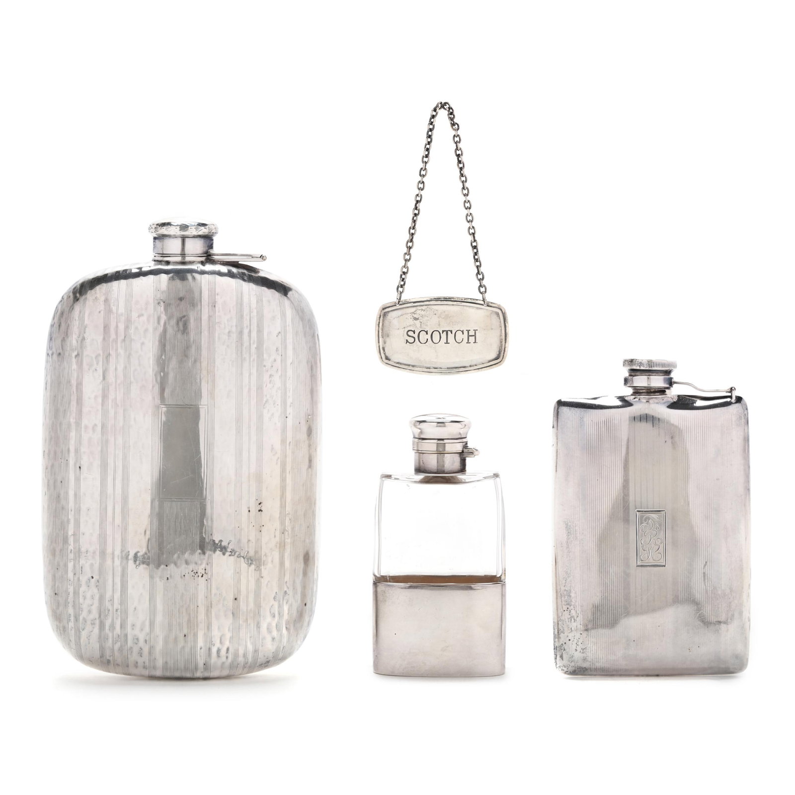 Three Sterling Silver Flask Bottles and a Liquor Tag: Three Sterling Silver Flask Bottles and a Liquor Tagthe largest, mark of Napier, featuring a hammered and engraved surface, not monogrammed (6 1/2 x 4 in.); the next, marked "Sterling", featuring engr