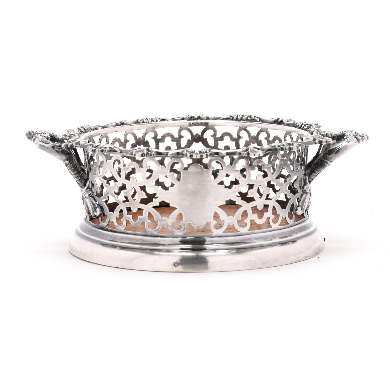 Antique English Silver-Plated Bottle Coaster: Antique English Silver-Plated Bottle Coasterearly 19th century, reticulated form with rocaille rim and scrolled handles, with wooden insert, not monogrammed. 3 x 9 x 7 1/2 in. Additional high-resolut