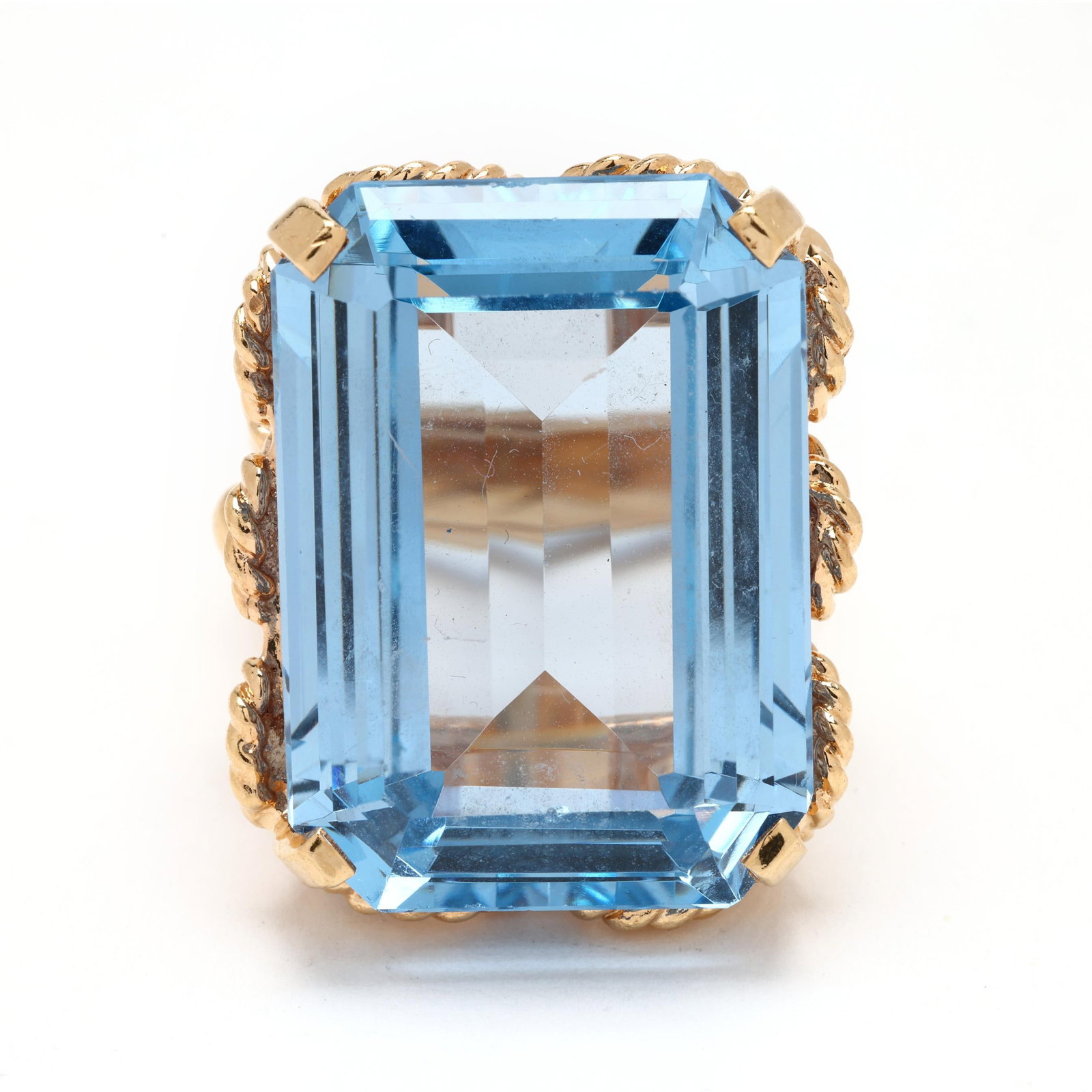 Gold and Synthetic Blue Spinel Ring: Gold and Synthetic Blue Spinel Ringcentered on an emerald cut synthetic blue spinel (24.96 x 17.95mm), set within a rope twist motif basket, testing 14KT. Ring size 5.5 (with sizing bar) 13.5 dwt. Ad