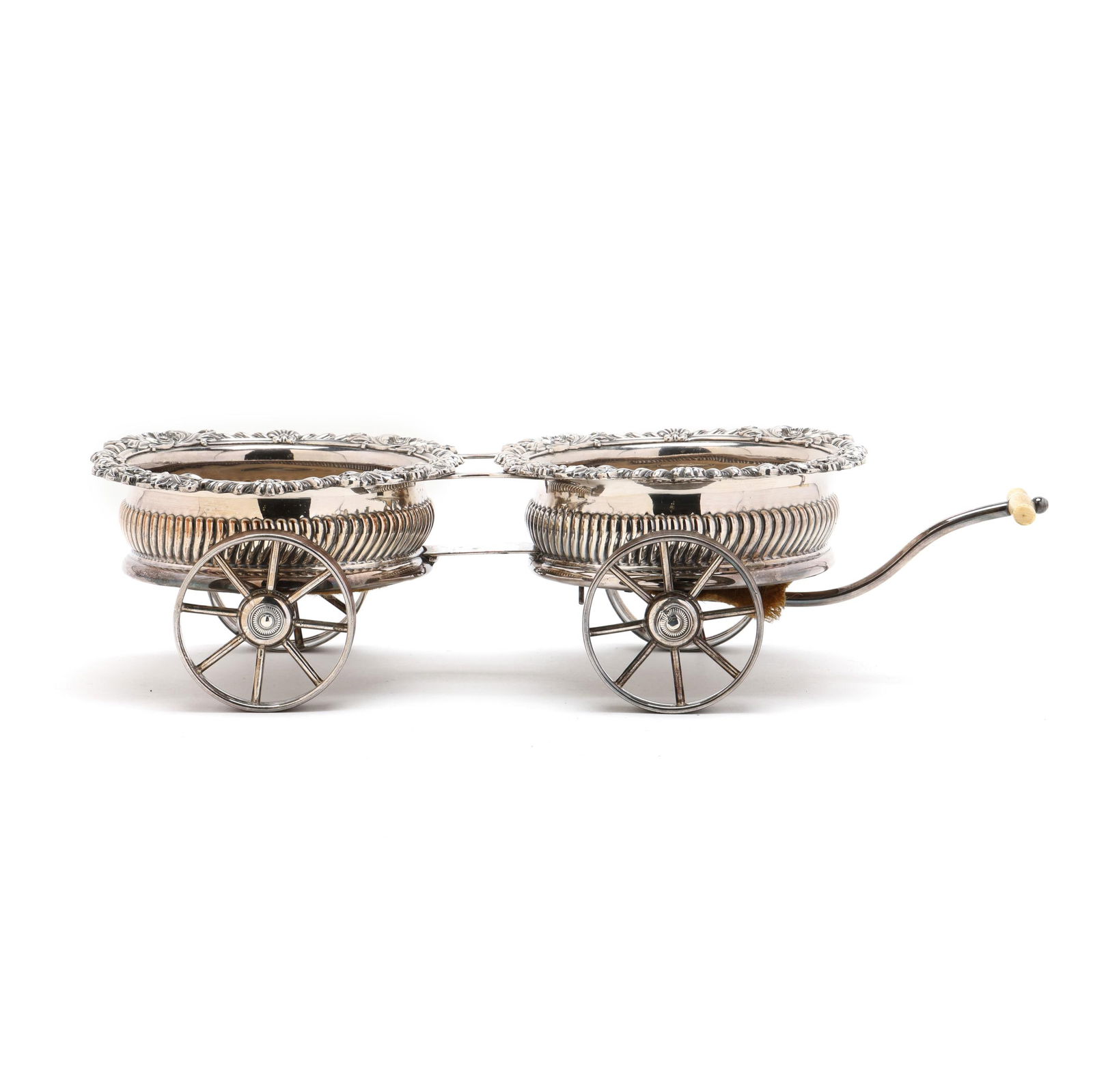 Sheffield Silver-Plated Double Wine Trolley: Sheffield Silver-Plated Double Wine Trolleylate 19th century, tabletop trolley with two floral and foliate decorative rimmed wine bottle coasters, each with turned wood base mounted to four wheels, fr