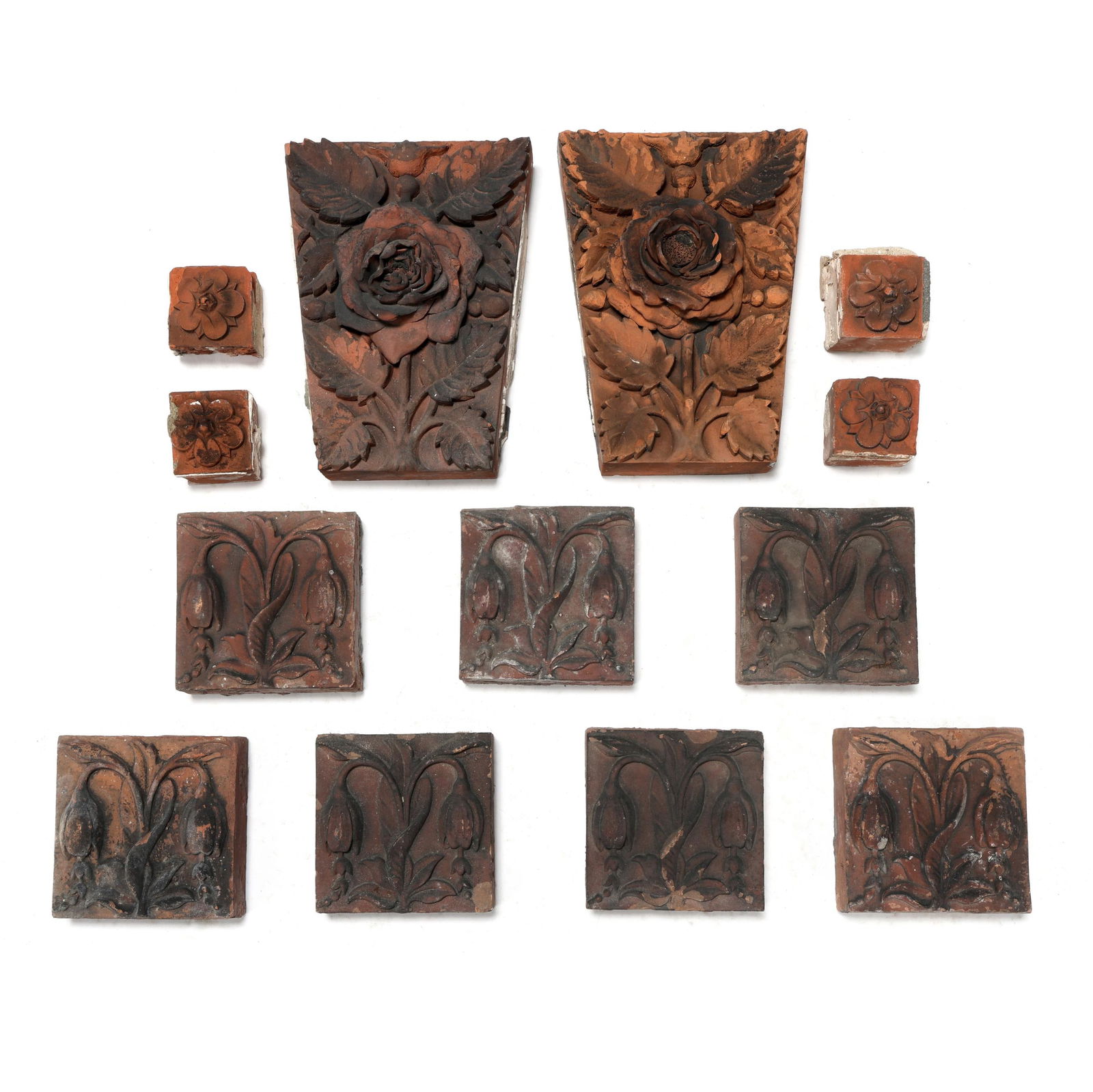 A Group of Victorian Terracotta Tiles: A Group of Victorian Terracotta Tileslate 19th century, (13) deeply molded terracotta tiles to include (4) small square tiles with Tudor roses (3 x 3 in.); (7) square tiles with Arts & Crafts style tu
