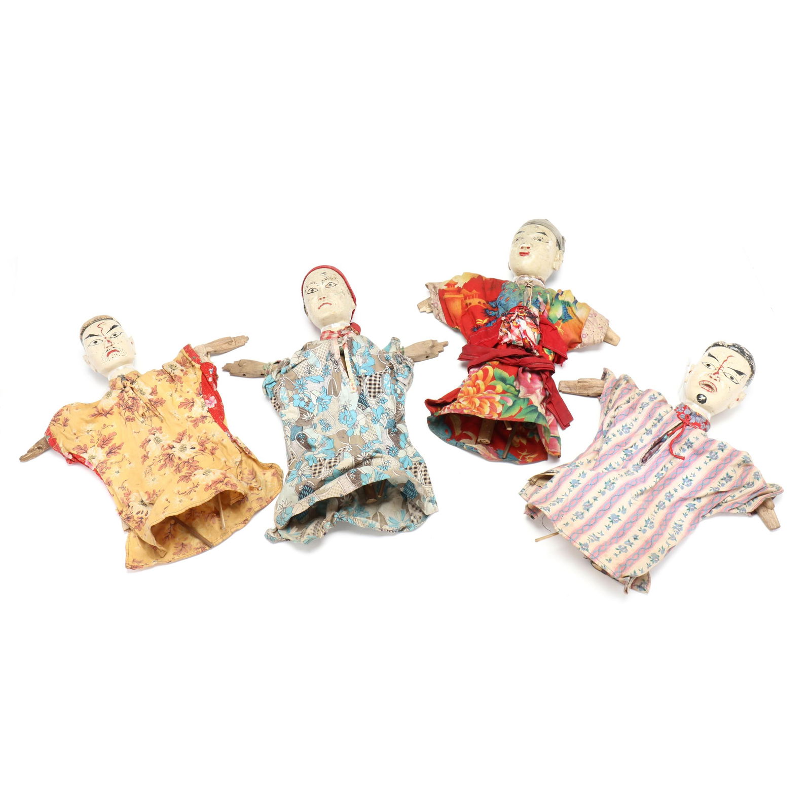 Four Chinese Antique Puppets: Four Chinese Antique Puppets circa 1900, four rod puppets each with an oval wooden head painted with an expressive face, wearing colorful patterned textiles, each with wooden rods under the fabric. Ea