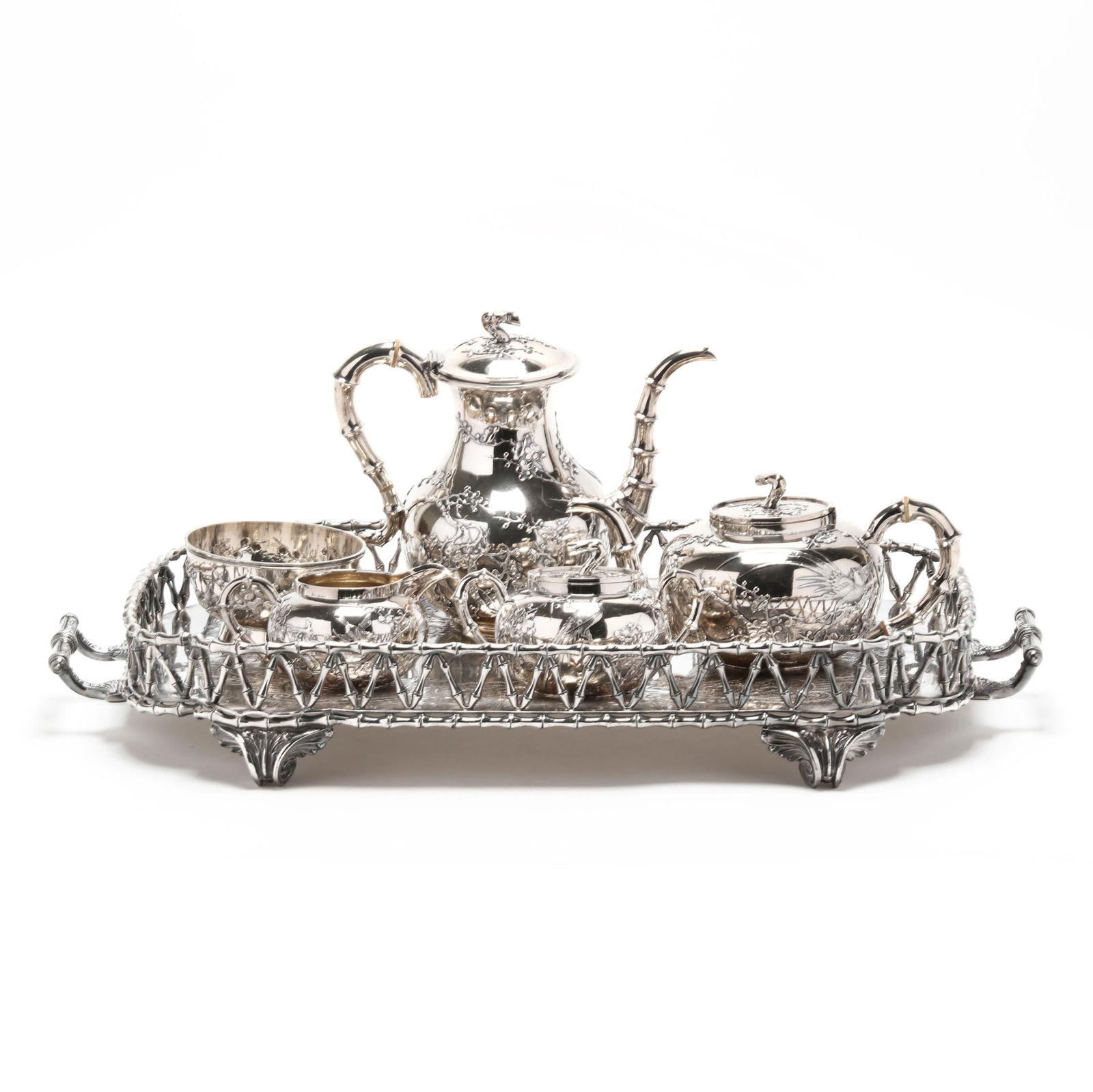 A Chinese Export Silver Assembled Tea Service: A Chinese Export Silver Assembled Tea Service20th century, an assembled service in a similar pattern with cherry blossom, bird decoration, and bamboo handles, includes a coffee pot (8 1/2 x 9 1/2 x 5