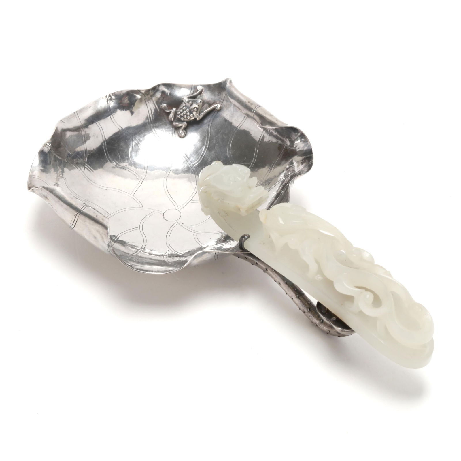 A Chinese Silver Lotus with Nephrite Jade Dragon Belt Buckle: A Chinese Silver Lotus with Nephrite Jade Dragon Belt BuckleQing dynasty (1644-1912), late 19th century, sterling silver lotus bowl featuring a frog to the wavy lotus leaf edge, engraved veining, and