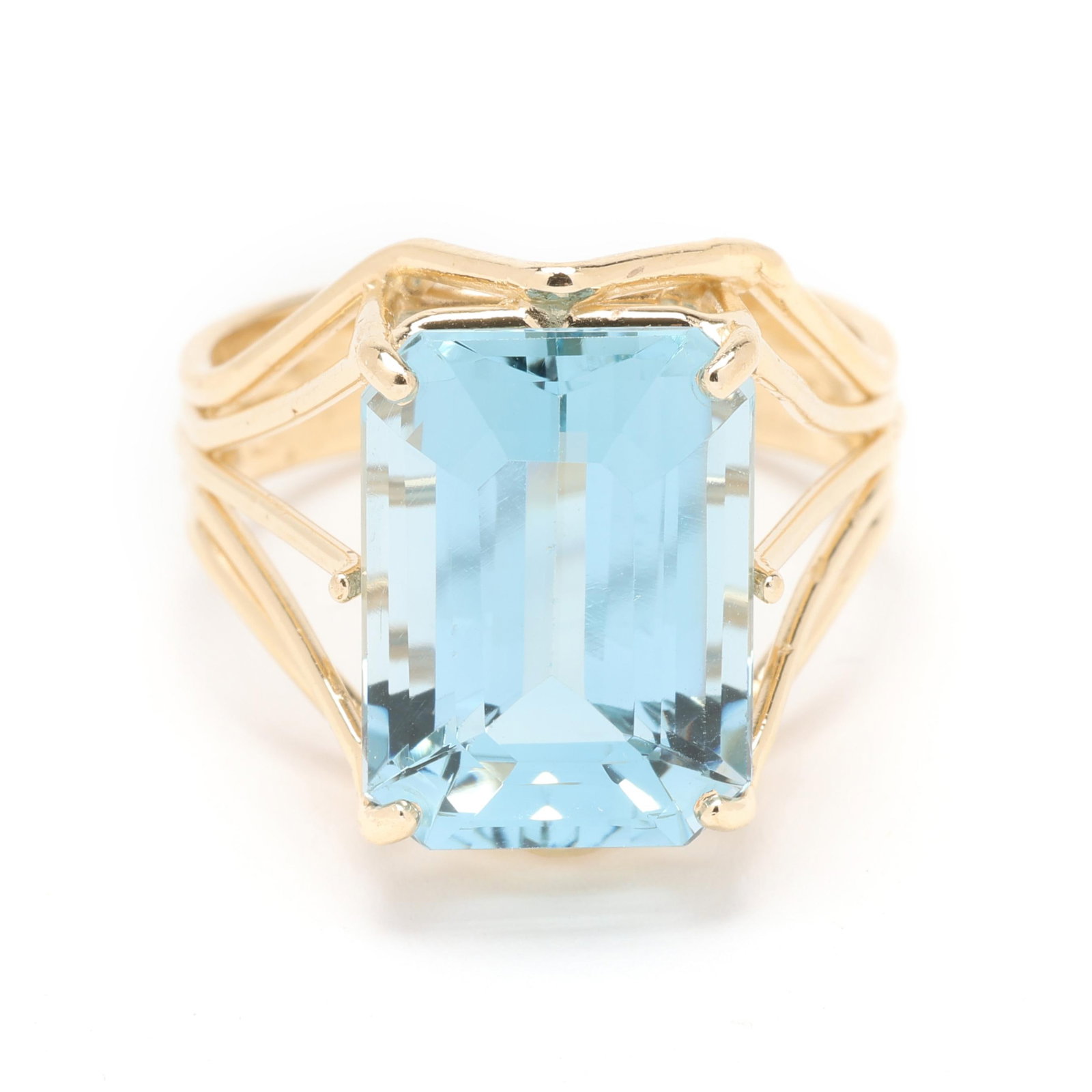 Gold and Blue Topaz Ring: Gold and Blue Topaz Ring centered on an emerald cut blue topaz (14.0 x 10.0 x 7.3mm) weighing approximately 9.50 carats set within a wire motif ring, stamped 14K / 585. 16mm; Ring size 7 4.0 dwt. 