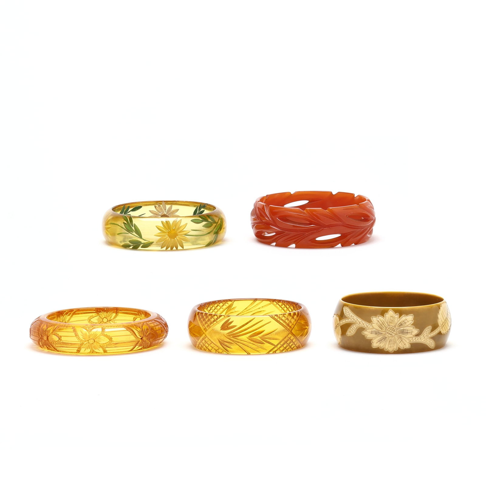 Group of Five Bakelite and Composition Bangle Bracelets: Group of Five Bakelite and Composition Bangle Bracelets to include: an opaque orange bangle in a leaf motif (1 x 7.75 in.); a translucent bangle with carved and painted daisy motif (.75 x 7.5 in.);