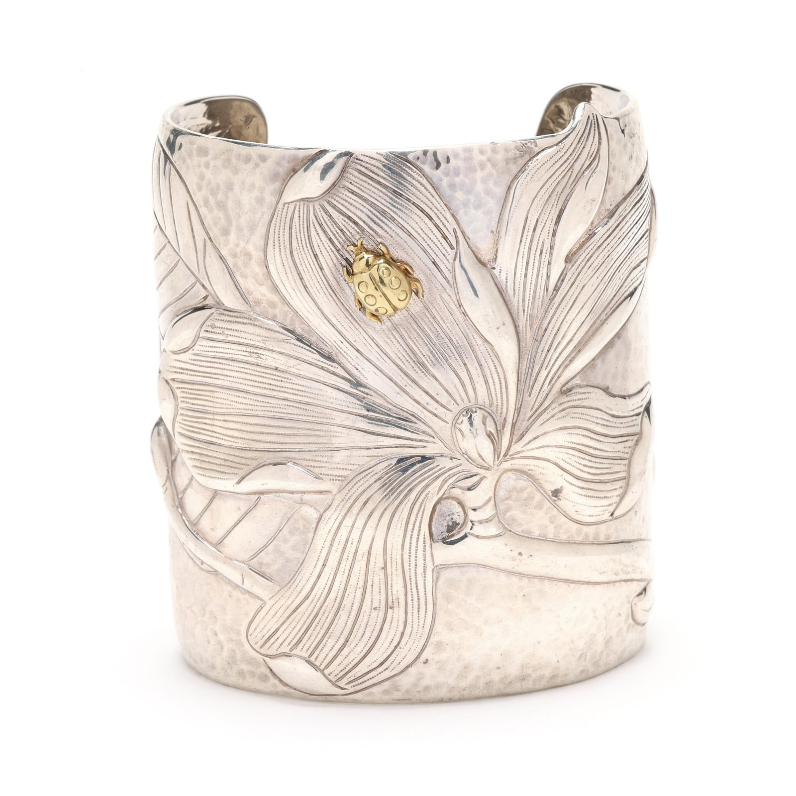 Silver and Gold Magnolia Cuff Bracelet, Tiffany & Co.: Silver and Gold Magnolia Cuff Bracelet, Tiffany & Co.circa 2001, from the Tiffany Nature collection, the wide silver cuff bracelet with engraved magnolia flower motif set with an applied gold ladybug,