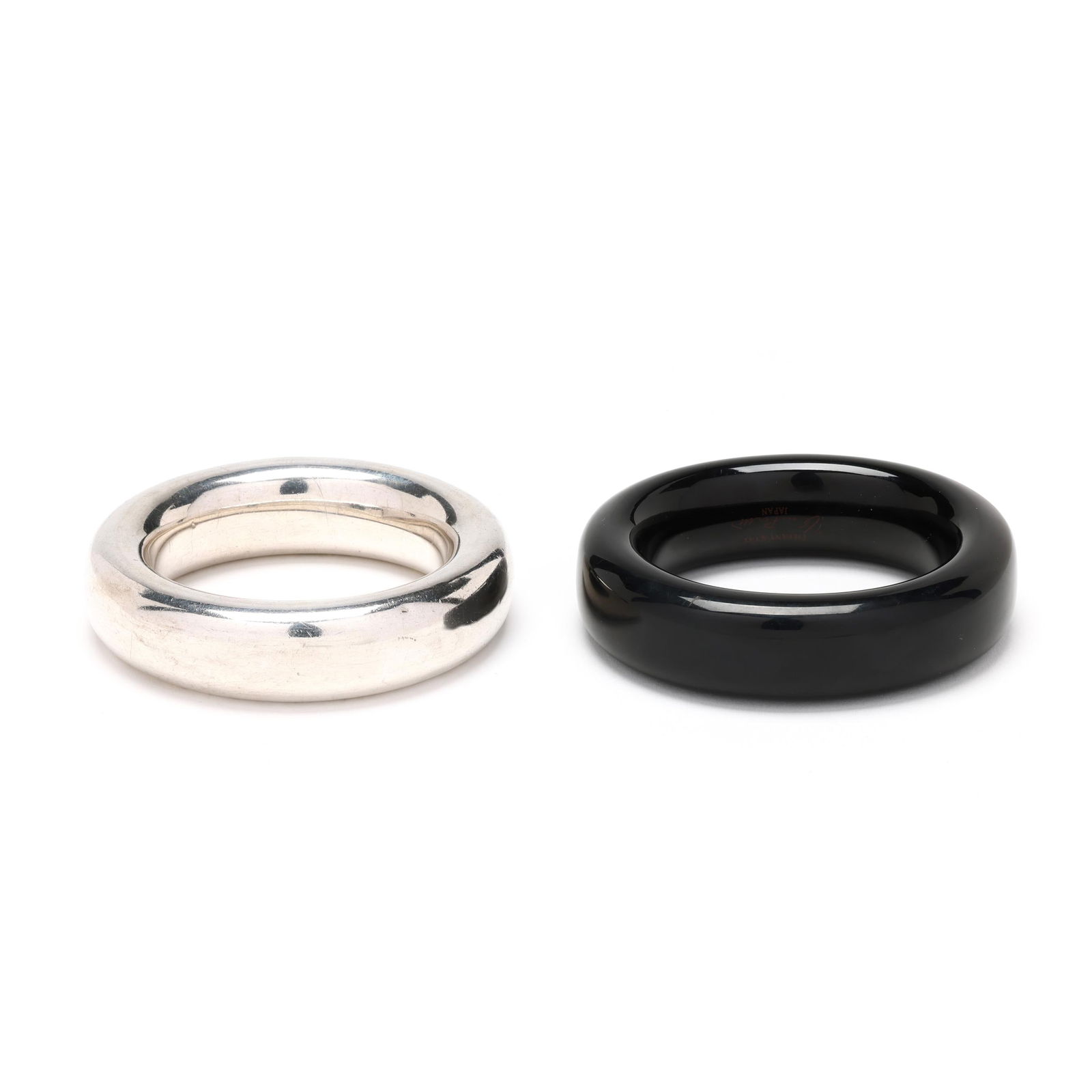 Two Doughnut Bangle Bracelets, Elsa Peretti for Tiffany & Co.: Two Doughnut Bangle Bracelets, Elsa Peretti for Tiffany & Co.to include: a silver Doughnut bangle bracelet, appears unsigned (likely worn), testing silver (7/8 x 7.5 in.); and a black lacquer Doughnut