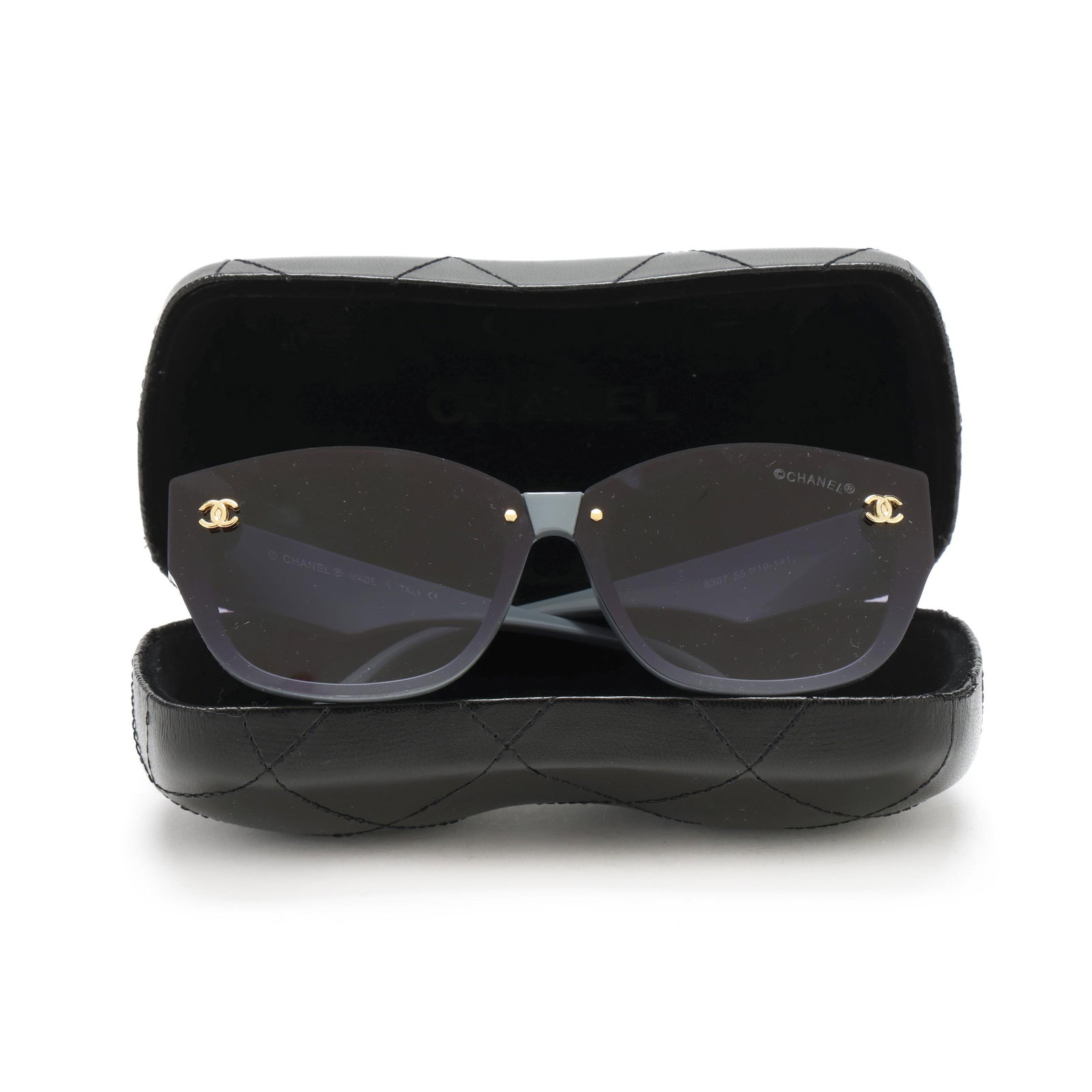 Chanel Sunglasses in Case: Chanel Sunglasses in CaseMade in Italy, #8307 having gray blue frame, and black lens with gold tone logo at each corner and on temples. With case and dust cloth. Private Collection, Raleigh, North Car