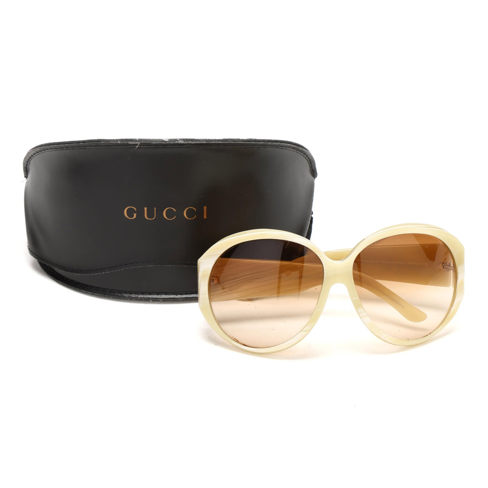 Gucci Sunglasses in Case: Gucci Sunglasses in CaseMade in Italy, GG2927 having cream colored frame and brown oval lens with rhinestone logo on left temple. With case. Private Collection, Raleigh, North Carolina Additional high