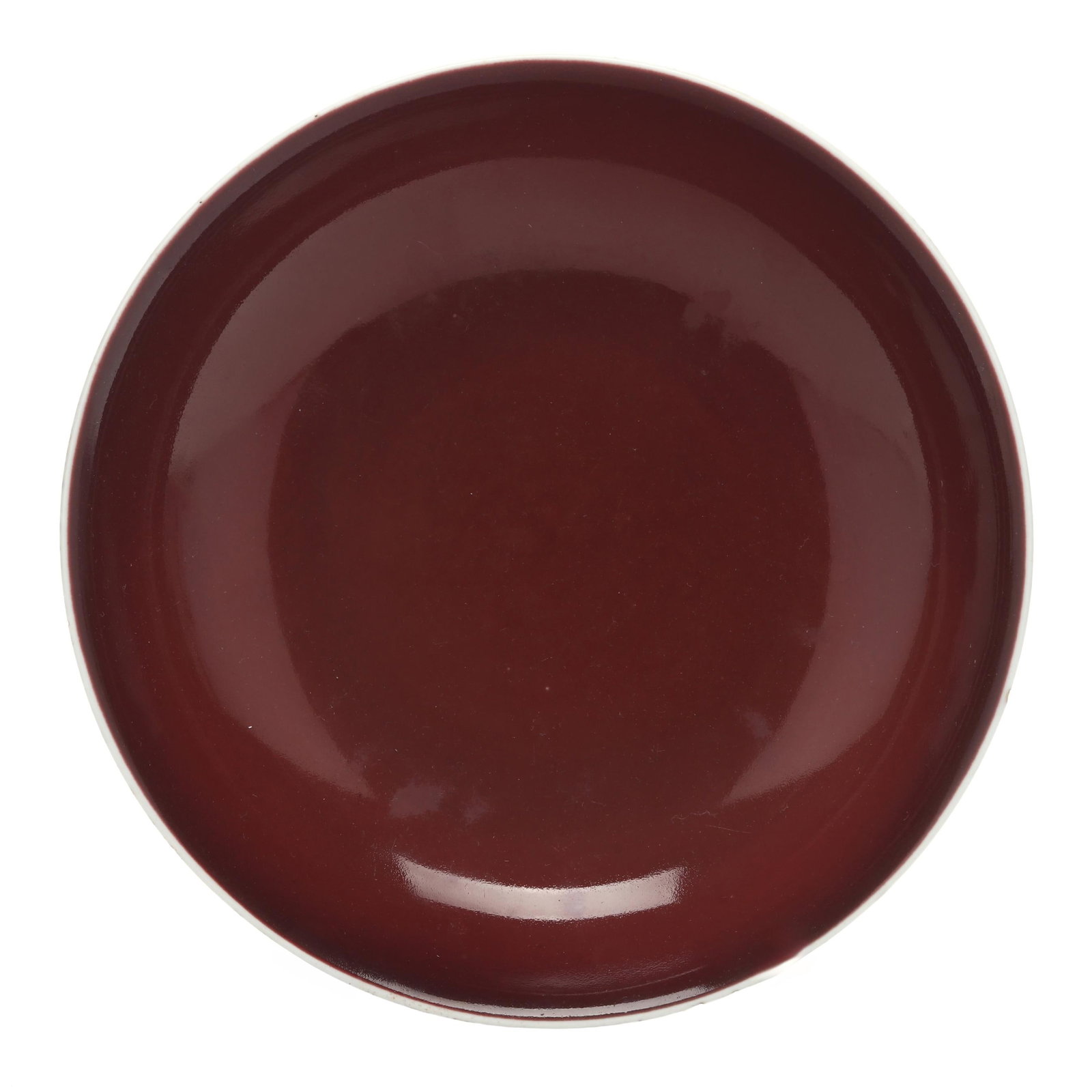A Chinese Porcelain Copper Red Glazed Bowl: A Chinese Porcelain Copper Red Glazed Bowl Qianlong Period (1736–1795), shallow bowl with rounded sides, glazed overall with a deep strawberry tone fading to a white glaze at the rim, the underside 