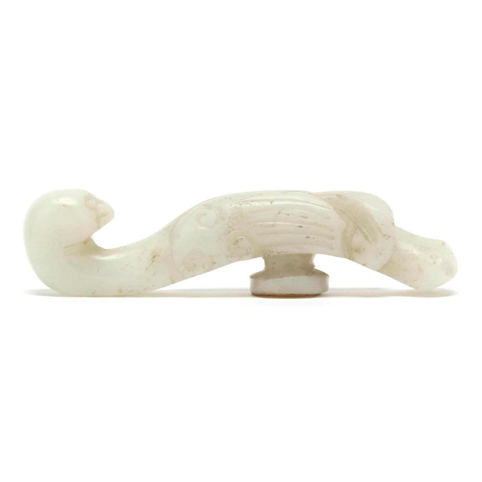 A Chinese Carved Jade Phoenix Belt Buckle: A Chinese Carved Jade Phoenix Belt Buckle Ming dynasty (1368-1644), a carved white nephrite jade belt hook in the shape of a bird, with old appraisal sticker to the underside. 3/4 x 3 x 3/4 in. From t