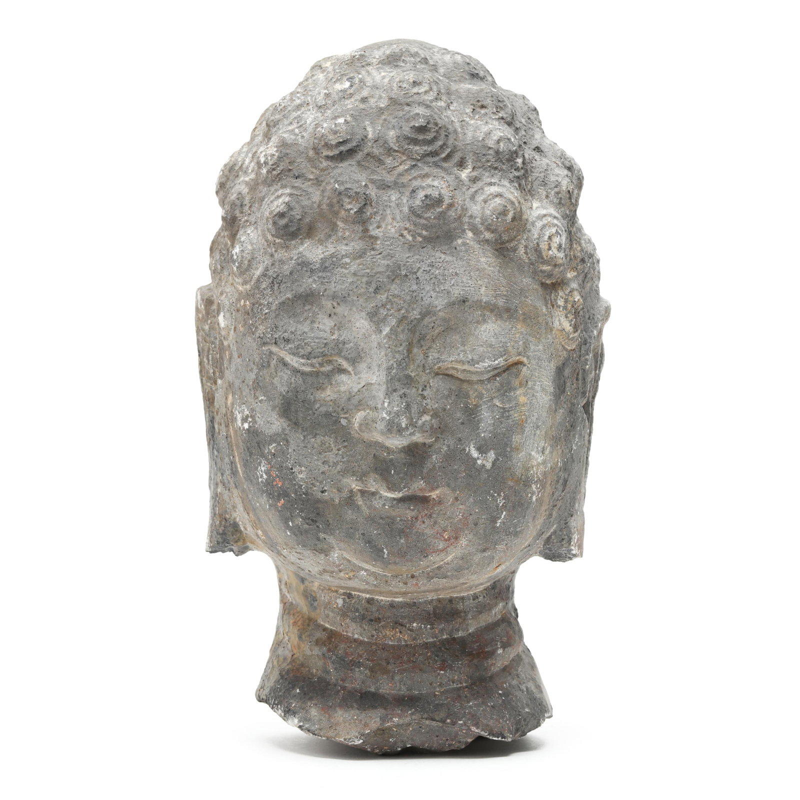 An Asian Carved Stone Buddha Head: An Asian Carved Stone Buddha Head Chinese or Korean, likely 7th or 8th century, stone with traces of white and red pigments, a rounded serene face having downcast eyes beneath gently arched brows, sof
