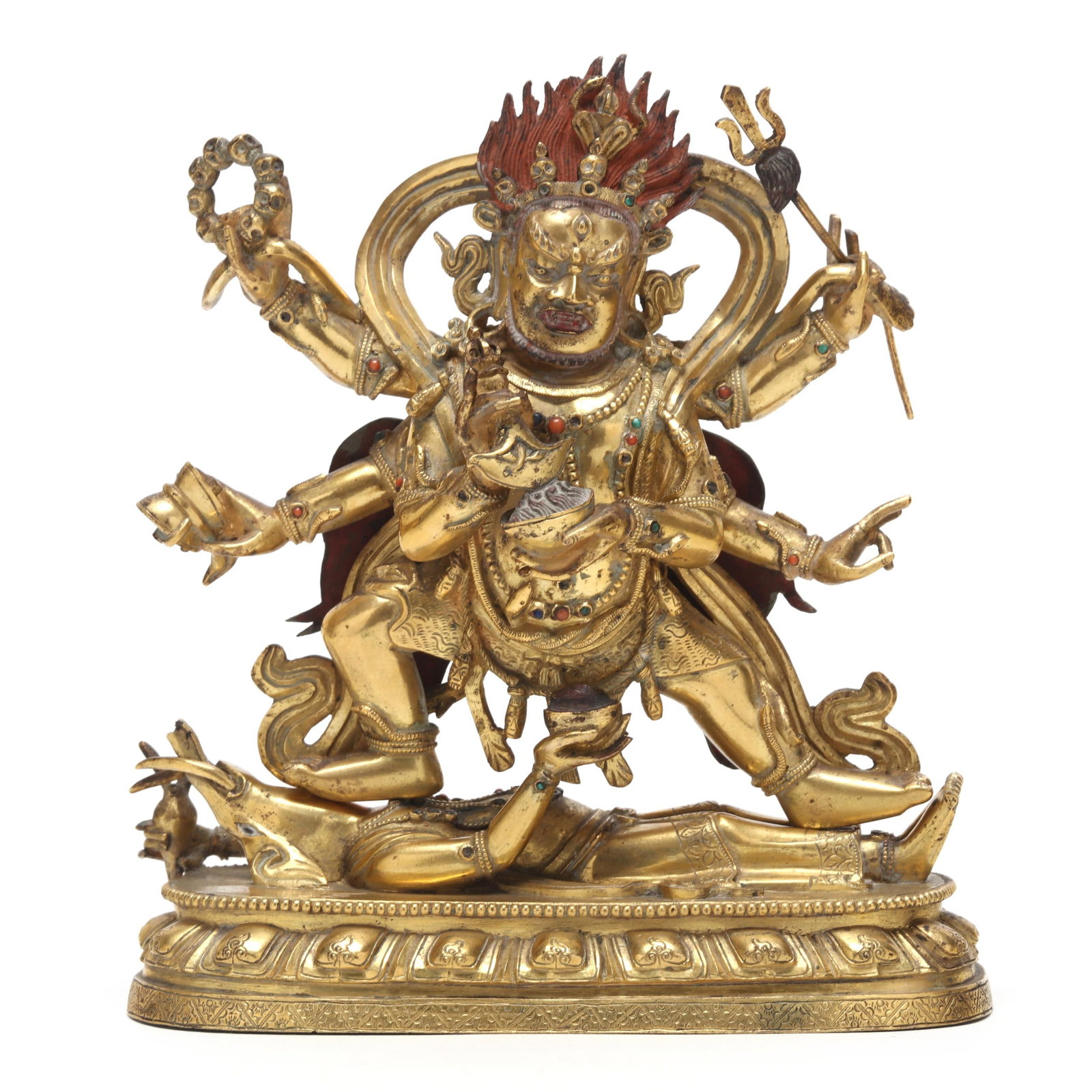 A Sino-Tibetan Gilt Bronze of a Six Armed Mahakala: A Sino-Tibetan Gilt Bronze of a Six Armed Mahakala 18th century, two part cast figure of Dharmapala Mahakala, with red pigment to hair topped by a skull head crown, a billowing ribbon wraps around his