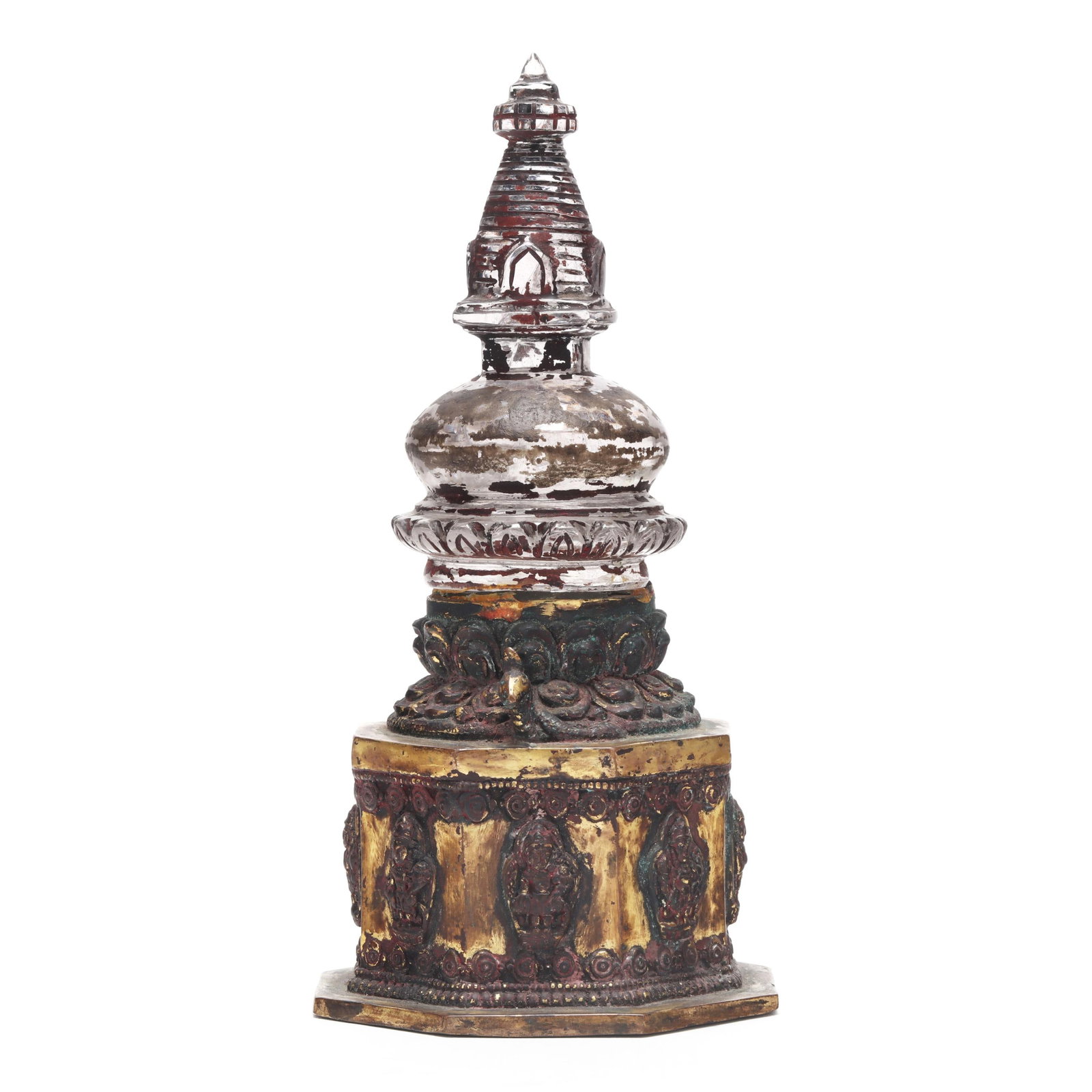 A Nepalese Rock Crystal Stupa on a Gilt Bronze Stand: A Nepalese Rock Crystal Stupa on a Gilt Bronze Stand 19th century, the top a rock crystal stupa with remains of pigments to the surface, it rests on a multi-tiered gilt bronze or copper alloy base wit