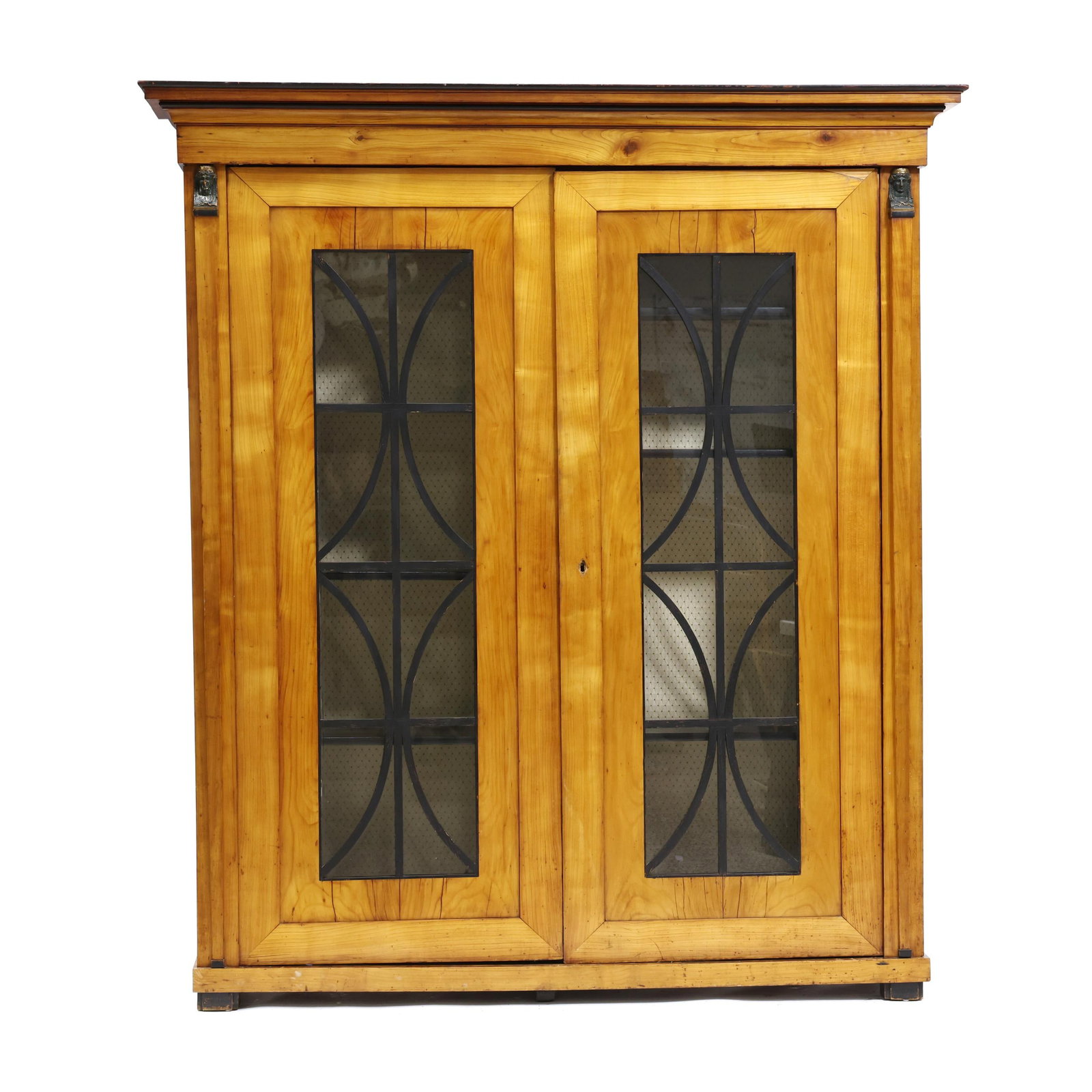 Biedermeier Fruit Wood Cabinet: Biedermeier Fruit Wood Cabinet circa 1830, pine secondary, multi-part form, dovetailed projecting cornice over two hinged glazed panel doors, caryatid stiles, fabric lined and shelved interior, confor