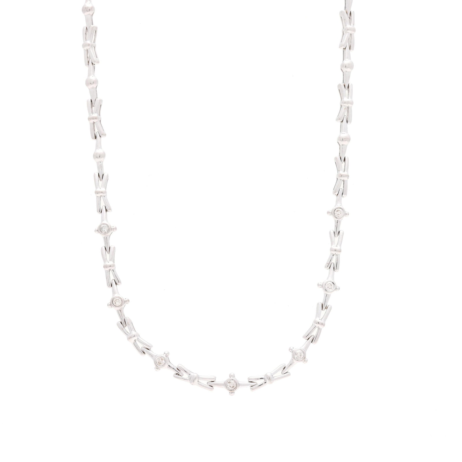 White Gold and Diamond Necklace: White Gold and Diamond Necklace the necklace in white gold with alternating X motif links and ball links, with seven bezel-set full cut round diamonds weighing approximately .20 total carat (J-K color