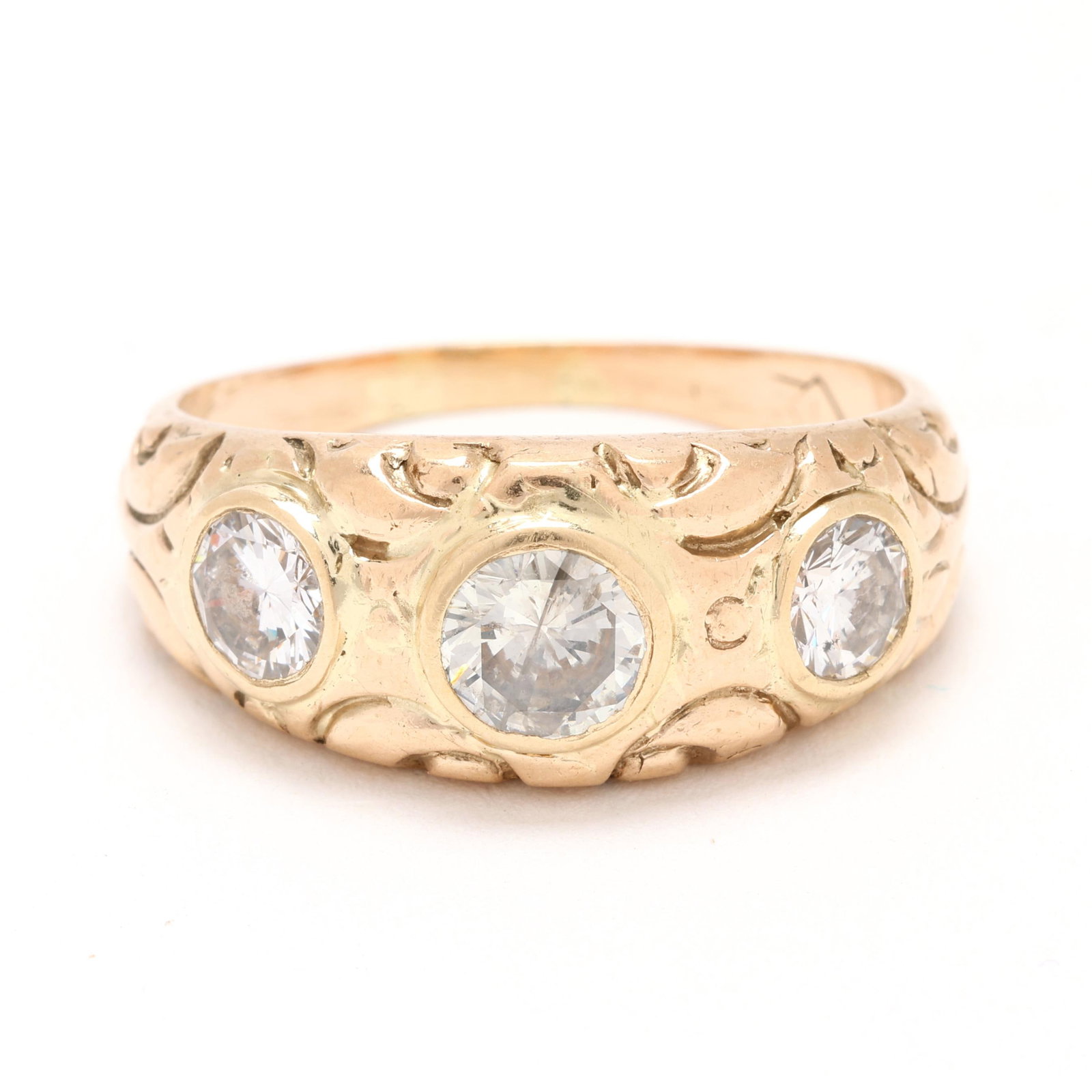 Gold and Three-Stone Diamond Ring: Gold and Three-Stone Diamond Ring set with full cut round diamonds weighing approximately 1.25 total carats (J-K color, I1-I2 clarity), with scrolled motif carving, stamped with a partial mark, testin